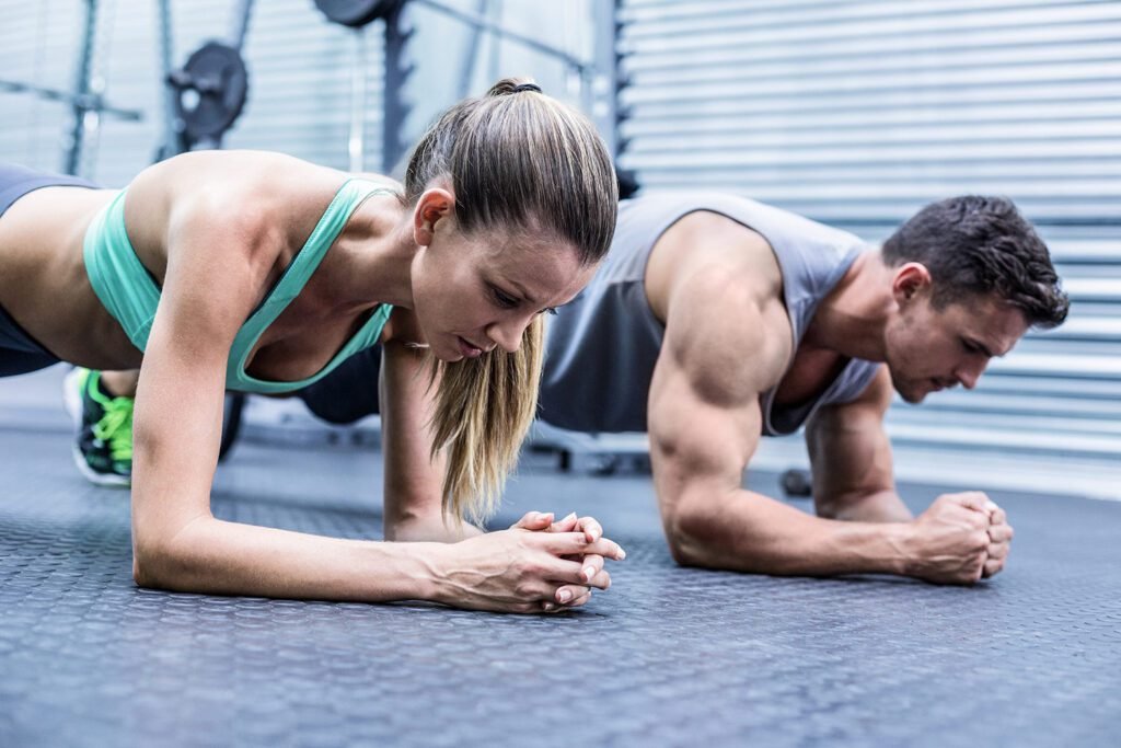 An image featuring a male and female performing plank exercises, symbolizing determination and goal-setting in bodybuilding